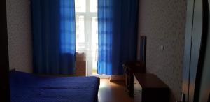 a bedroom with blue curtains and a bed and a window at Apartment Rustaveli 59 in Batumi +18 photos