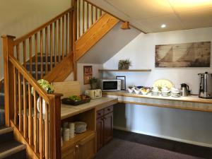 a kitchen with a counter and a staircase at Redwings Lodge Rutland in Uppingham
