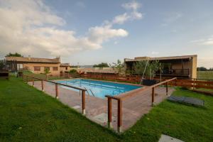 een zwembad in een tuin naast een huis bij Alcabala del Viento in Noriega