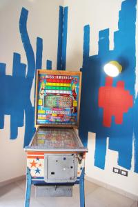 staroświecka maszyna do pinballa przed ścianą w obiekcie Urban Pop 2 BnB w Katanii