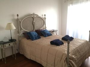 a bedroom with a bed with blue pillows on it at Over the Rainbow in Almada