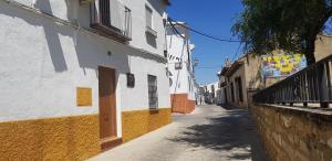 un callejón con un edificio blanco y amarillo en Casa del Mirador, en Arjona
