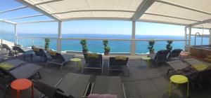 a restaurant with tables and chairs and a view of the ocean at Hôtel Riva Art & Spa in Menton
