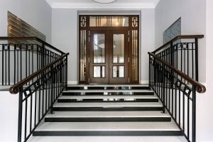 a hallway with stairs with a wooden door at Very Berry - Chełmońskiego 20 - Deluxe Apartments, check in 24h in Poznań