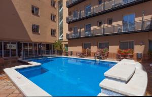 une grande piscine en face d'un bâtiment dans l'établissement Hotel Mar de Tossa, à Tossa de Mar