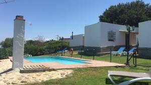 een klein zwembad met een persoon ernaast bij Villas de la Ermita in Vejer de la Frontera