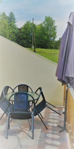 2 sillas y una sombrilla en el patio en Siesta Üdülő, en Igal