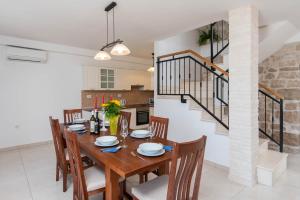 un comedor con mesa y sillas y una escalera en Villa Loviste Paradise, en Lovište