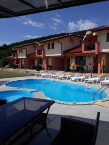 a large swimming pool with chairs and a building at Gledkata Complex in Skobelevo
