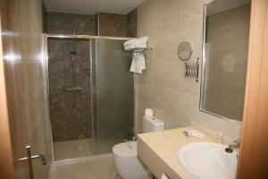 a bathroom with a shower and a toilet and a sink at Hostal Restaurante Grela in Pozo Alcón