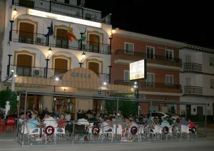 un grupo de personas sentadas en mesas frente a un edificio en Hostal Restaurante Grela, en Pozo Alcón