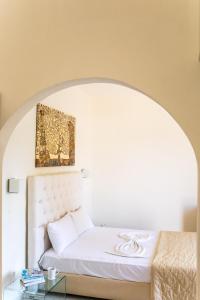 a bedroom with a white bed with a picture above it at Blue Green Bay in Panormos Skopelos