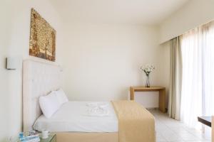 a white bedroom with a bed and a window at Blue Green Bay in Panormos Skopelos