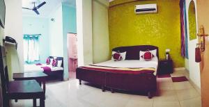a bedroom with a bed and a chair in a room at Satkar Hotel in Jaipur