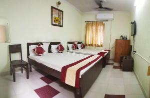 a bedroom with two beds with red and white pillows at Satkar Hotel in Jaipur