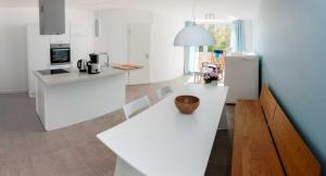 a kitchen with white counters and a bowl on a table at Lotsenstieg 2 Kajuete 05 in Ostseebad Karlshagen
