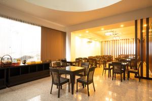 a dining room with tables and chairs in a restaurant at Intouch Riverside Hotel in Pakse