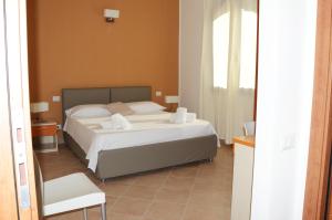 1 dormitorio con 1 cama y 1 silla blanca en Hotel '904, en Buggerru