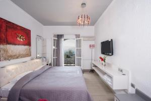a bedroom with a large bed and a tv at Aegialis Hotel & Spa in Aegiali
