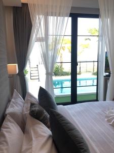 a bedroom with a bed with a view of a pool at La Playa Beach Front Pool Villa Cha-am,Huahin in Cha Am