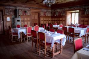 a dining room with white tables and red chairs at Hotel La Villa della Regina in Gressoney-la-Trinit&eacute;