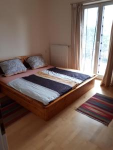 1 dormitorio con cama de madera y ventana grande en Holzhaus mit grüner Aussicht zum Erholen, en Burgheim
