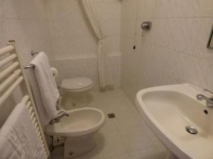 " Il Bersagliere " Dependance Hotel la Pace في أسكيانو: حمام أبيض مع حوض ومرحاض