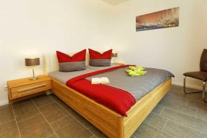 オストゼーバート・カールスハーゲンにあるKapitaensweg 2 Kajuete 04のベッドルーム1室(大型ベッド1台、赤い枕付)