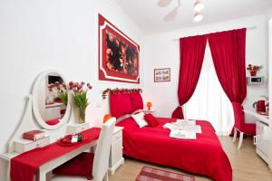 Dormitorio rojo con cama roja y espejo en Etere in Prati Rooms, en Roma