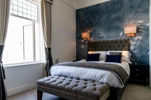 1 dormitorio con 1 cama grande con almohadas azules en The Strand Hotel former Home of Oscar Wilde & Caffe Vergnano 1882, en Bray