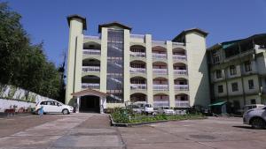 a large building with cars parked in front of it at Landmark Hills in Shillong