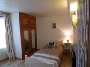 a bedroom with a bed and a table and a window at L'Ostalet in Prugnanes