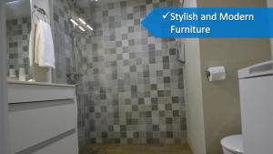 a bathroom with a sink and a shower with a toilet at Lukentum Suites in Alicante +41 photos