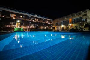 a large swimming pool in front of two buildings at night at Ros Mari in Lazarevskoye
