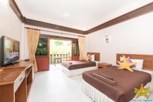 a hotel room with two beds and a flat screen tv at Asia Divers Resort in Ko Tao