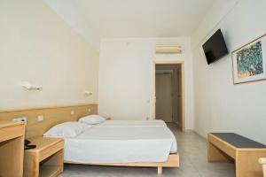 1 dormitorio con 1 cama blanca y TV en Hotel Riviera en Rodas