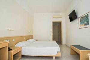 a bedroom with a white bed and a tv at Hotel Riviera in Rhodes Town