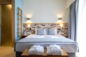 a bedroom with a large bed with towels on it at Blue Green Bay in Panormos Skopelos