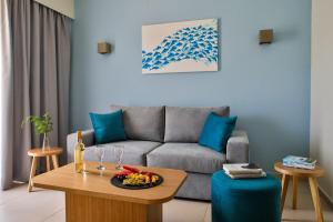 a living room with a couch and a table with wine glasses at Blue Green Bay in Panormos Skopelos
