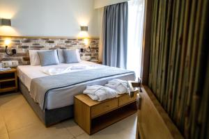 a bedroom with a bed with towels on it at Blue Green Bay in Panormos Skopelos
