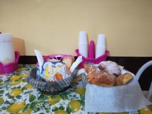 einen Tisch mit zwei Körben Gebäck und Kerzen in der Unterkunft Zurigo Val di Noto in Noto