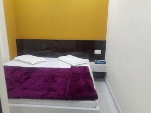 a bedroom with a bed with a purple blanket at Hotel Moon Sky Ajmer in Ajmer