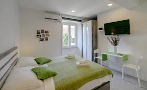 um quarto com uma cama e uma televisão na parede em Timeless City Center Apartments em Dubrovnik