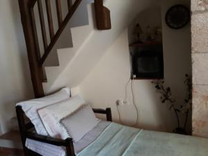 Habitación con cama y escalera con TV. en Koutouloufari Cosy Cretan Cottage, en Hersonissos