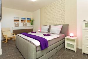 a bedroom with a bed with a purple blanket on it at Kapitaensweg 2 Kajuete 05 in Ostseebad Karlshagen