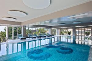 a pool in a hotel with chairs and windows at Hotel AMI Budva Petrovac in Petrovac na Moru