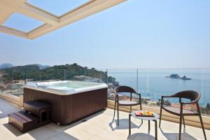 a hot tub on a balcony with a view of the ocean at Hotel AMI Budva Petrovac in Petrovac na Moru