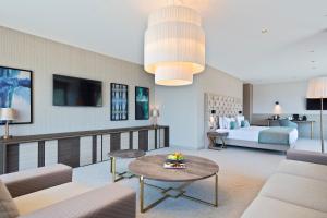 a living room with a couch and a bed and a table at Hotel AMI Budva Petrovac in Petrovac na Moru