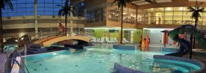 a large swimming pool with a slide in a building at Hotel Jarota in Jarocin