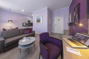 a living room with a couch and a table with a laptop at Apartmenthaus Burgenheimat in Rhens bei Koblenz in Rhens